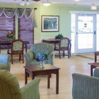 A cozy and well-furnished living room with armchairs and tables.