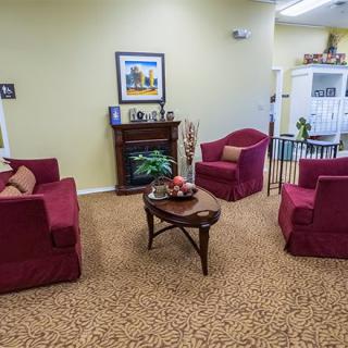 A cozy living room with red armchairs and a wooden coffee table.