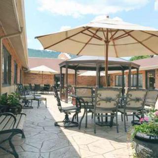 A well-furnished outdoor patio area with tables, chairs, and umbrellas.