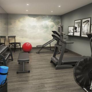 A modern gym room featuring a treadmill, dumbbells, and other exercise equipment.