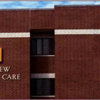 A brick building with a healthcare sign and windows.