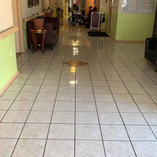 A tiled indoor hallway with furniture and decorations.