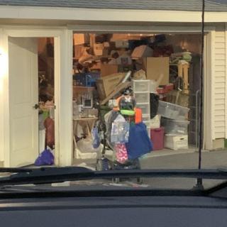 A cluttered garage filled with various items, including a bicycle and several boxes.