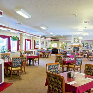 A spacious and elegantly decorated restaurant dining area with neatly arranged tables and chairs.