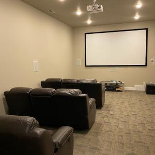 A cozy home theater setup with comfortable seating and a large screen.