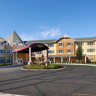 A large residential building with a welcoming entrance and landscaped surroundings.