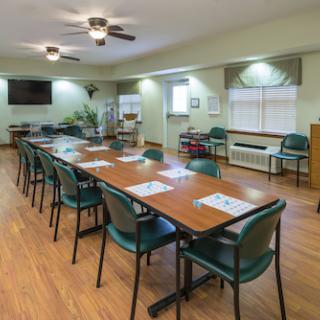 A spacious meeting room equipped with a long table and chairs, ideal for collaborative discussions.