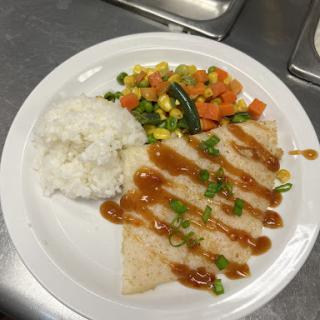 A delicious plate featuring sauted vegetables, rice, and a sauced dish.