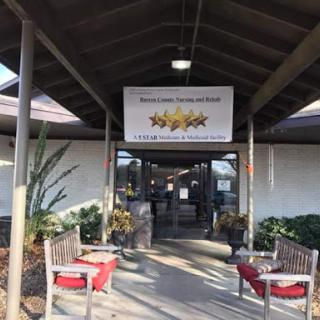 Entrance of a welcoming establishment with outdoor seating and decorative plants.