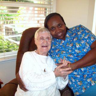 An elderly woman and her caregiver sharing a joyful moment together.