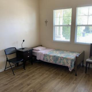 A minimalist bedroom with a single bed and wooden flooring.
