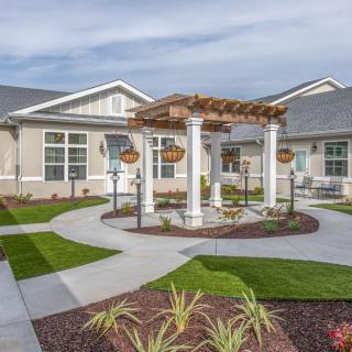 A modern residential courtyard featuring a pergola and landscaped pathways.