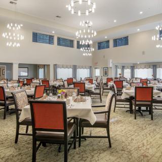 A spacious dining area with elegant decor and chandeliers.