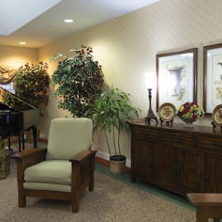 A cozy lobby area featuring comfortable seating, decorative plants, and a piano.