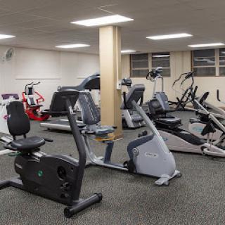 A view of a well-equipped gym featuring various cardio machines.
