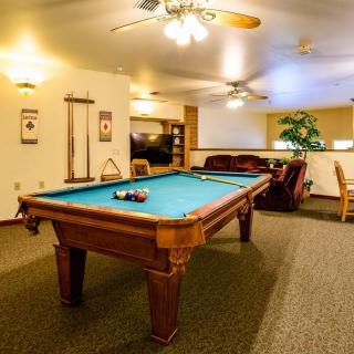 A cozy game room featuring a pool table and comfortable seating.