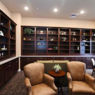 A cozy library room with bookshelves and comfortable chairs.
