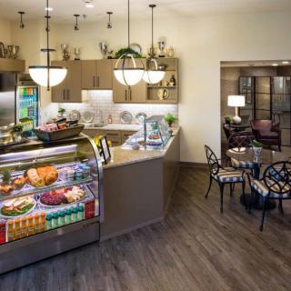A cozy cafe interior with a display case and seating area.