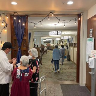 People entering a restaurant with a cozy interior and string lights.