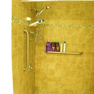 A shower with tiled walls, equipped with a grab bar and various shampoo bottles on a shelf.