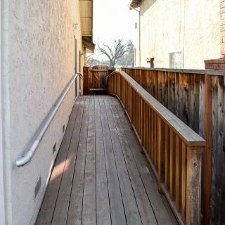 A wooden ramp with handrails providing accessible entry to a building.