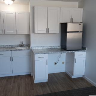 A modern kitchen featuring white cabinets and stainless steel appliances.