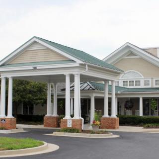 A building entrance with columns and a covered driveway.