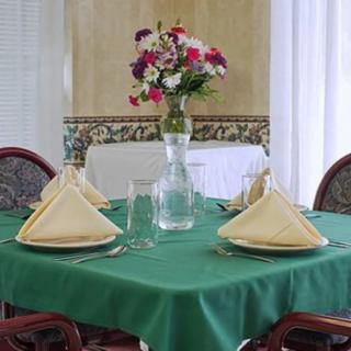 A beautifully set dining table with a floral centerpiece and neatly arranged napkins and glasses.