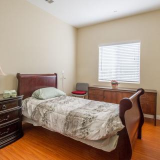 A cozy bedroom with a single bed, wooden furniture, and minimalist decor.