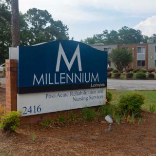 Sign for Millennium office in front of a building.