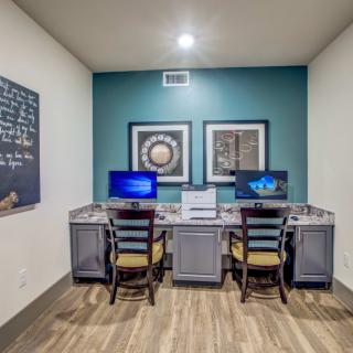 A small office workspace equipped with two computers and chairs, featuring minimalist interior design.