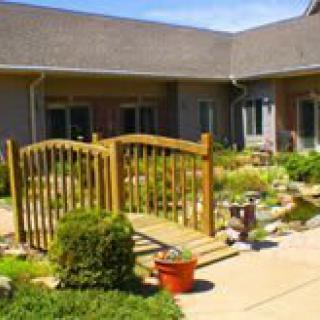 A beautifully landscaped courtyard with a wooden gate and lush greenery.
