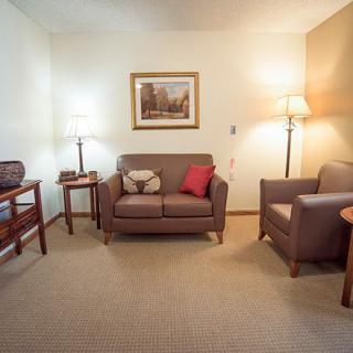 A cozy living room with a sofa, armchair, and warm lighting.