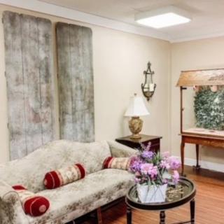 A cozy living room with elegant decor, featuring a plush sofa, decorative pillows, and a floral arrangement on the table.