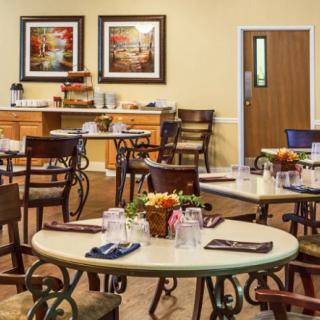 A cozy dining area with neatly arranged tables and chairs, set for a meal.