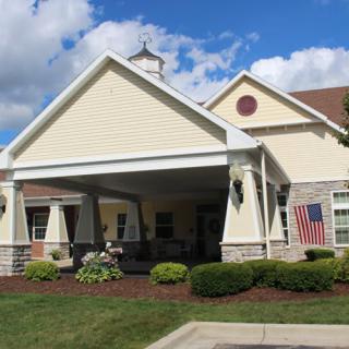 A residential building with a porch and well-maintained lawn.