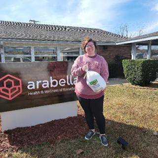 A volunteer at Arabella Health & Rehabilitation poses with a donation.