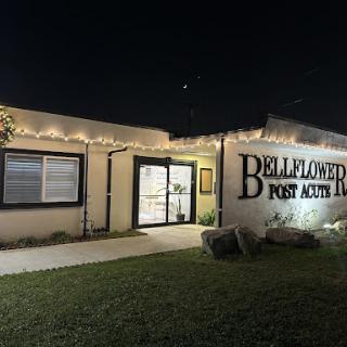 A brightly lit storefront of Belleflower Post Acute, showcasing its welcoming entrance at night.