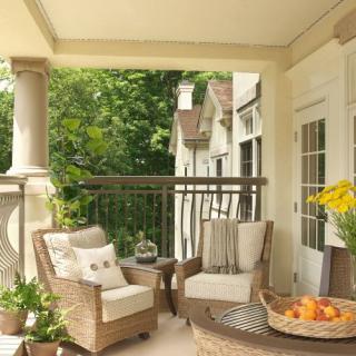 A cozy patio with wicker furniture and lush greenery.