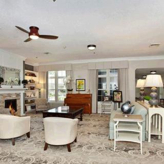 A cozy and elegantly designed living room with a fireplace, bookshelves, and comfortable seating.