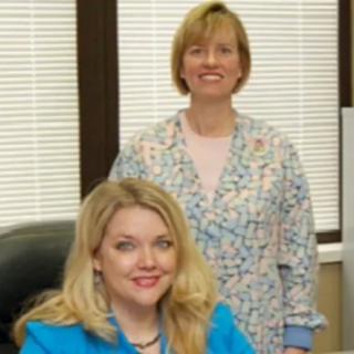 Two women in an office setting, both smiling.