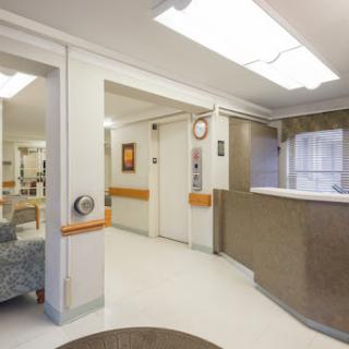 A bright and welcoming hospital reception area with comfortable seating and an elevator.