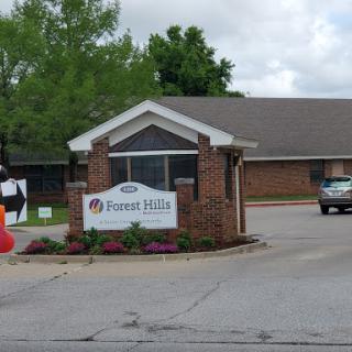 Entrance to Forest Hills, featuring a welcoming sign and landscaped surroundings.