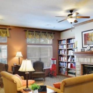 A cozy living room with comfortable seating, a bookshelf, and a fireplace.