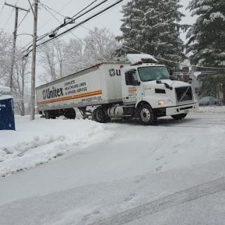 A truck navigating through a snowy street.