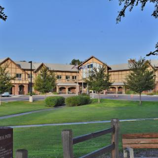 A picturesque view of a charming building surrounded by lush greenery and a clear blue sky.