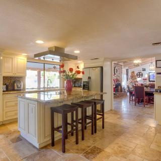 A spacious and modern open-plan kitchen with an island and bar stools.
