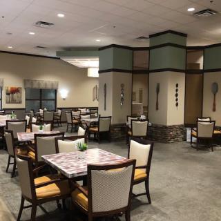 An empty restaurant dining area with neatly arranged tables and chairs.
