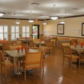 A well-lit dining area with multiple tables and chairs arranged neatly.