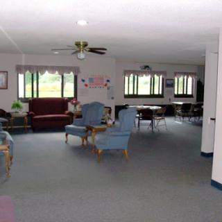 A spacious lounge area featuring comfortable seating and natural light from large windows.